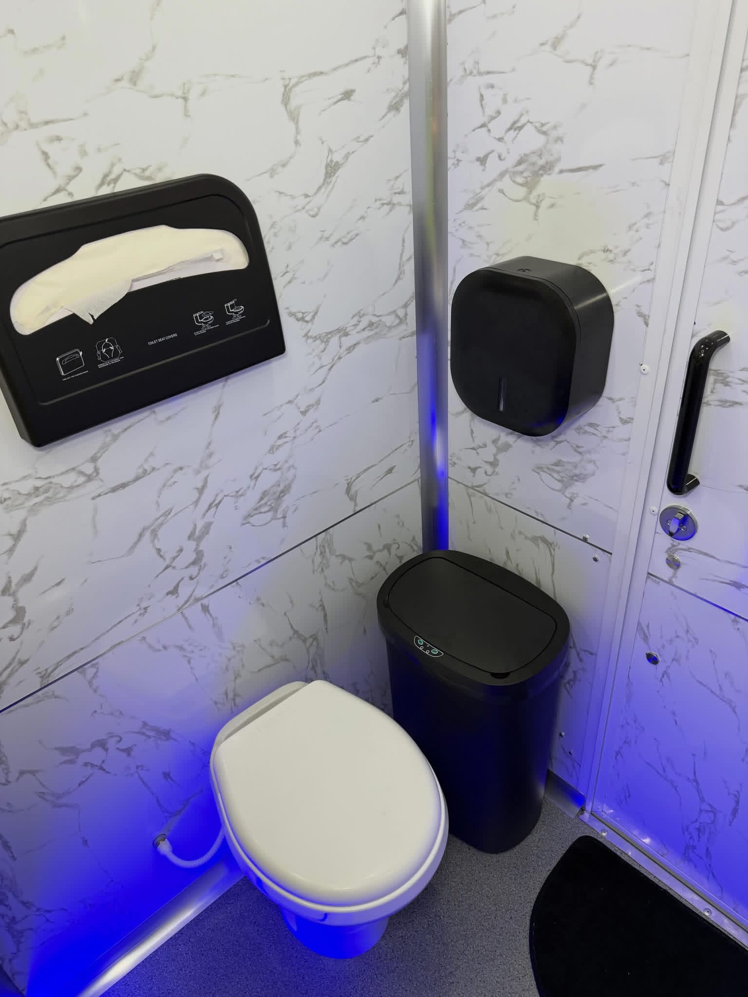 Private stall with flushing toilet, seat covers and sapphire LED floor lighting